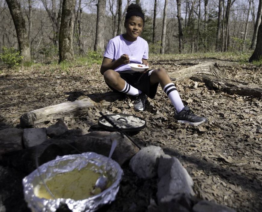 Boy enjoys dutch oven meal in nature