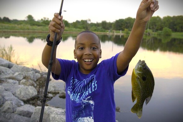 Boy smiles and holds bluegill 
