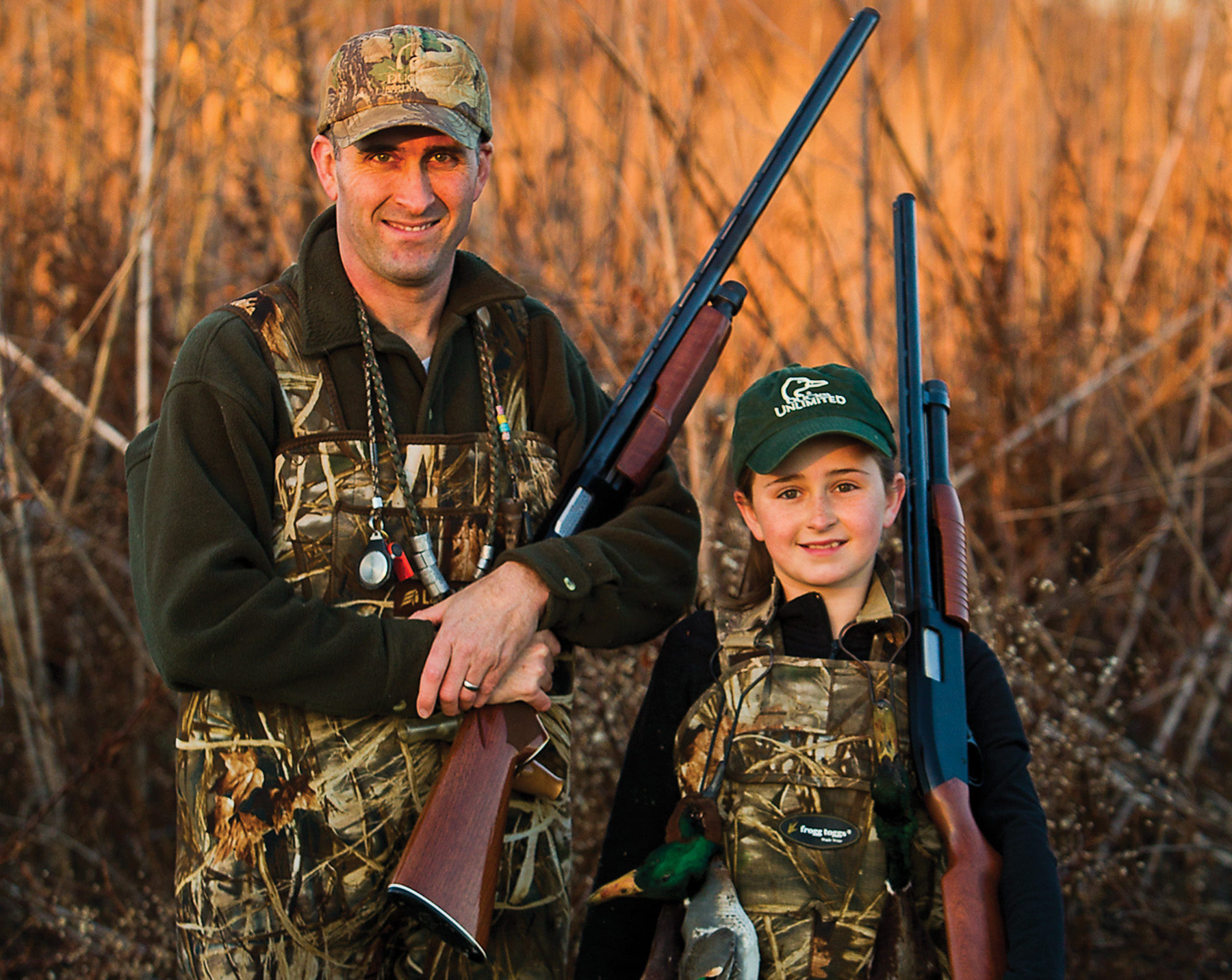 Father and young girl duck hunters pose for the camera
