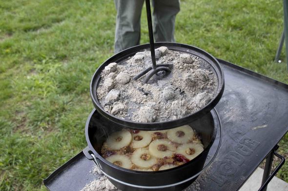 Pot full of food cooking over a campfire.