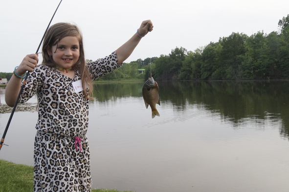Little girl holding up a fish.