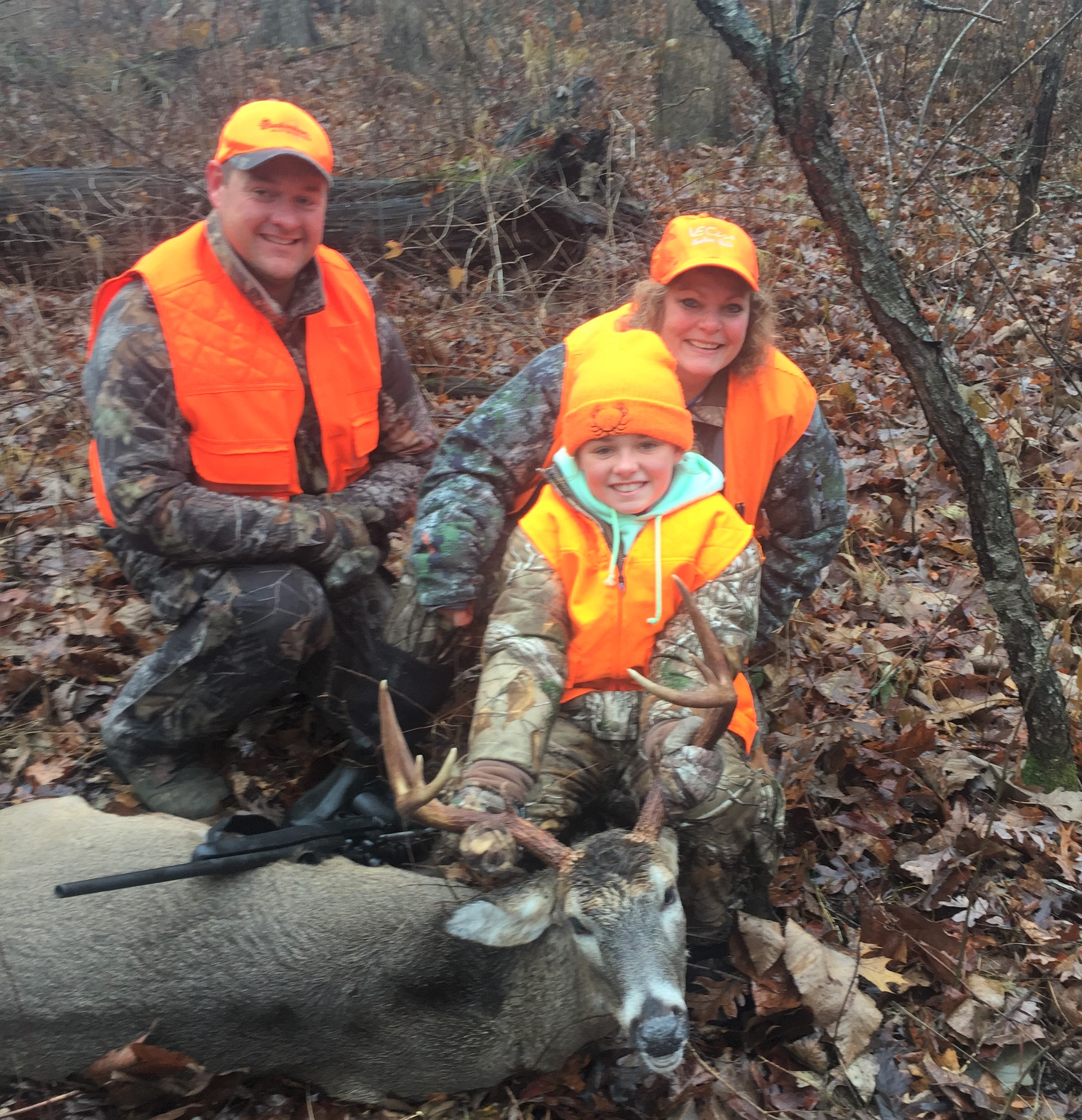 youth with harvested buck and dad and guide