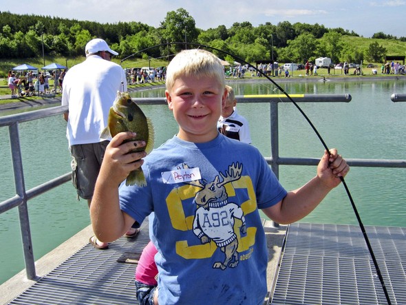 Kid holding up his fish caught at Lost Valley Hatchery.