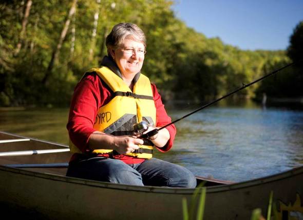 Woman fishing from canoe