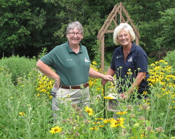 Jamie Koehler, assistant manager at the Cape Girardeau Conservation Nature Center, and Judy Lang, a nature center volunteer, install a bee hotel in a native plant garden.