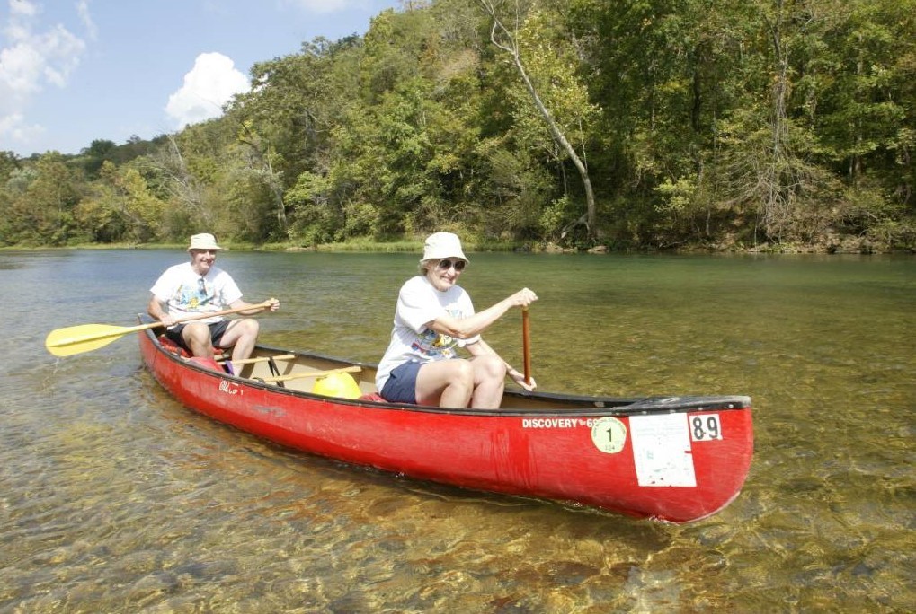A couple paddles a canoe on a lake
