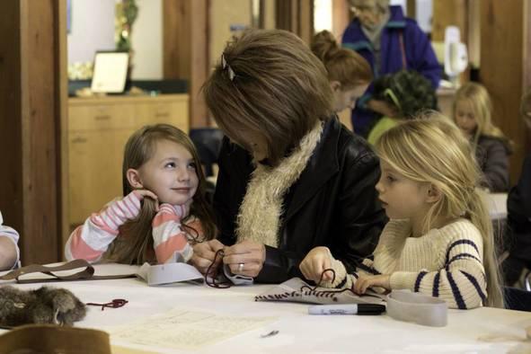An adult and two little girls making crafts.