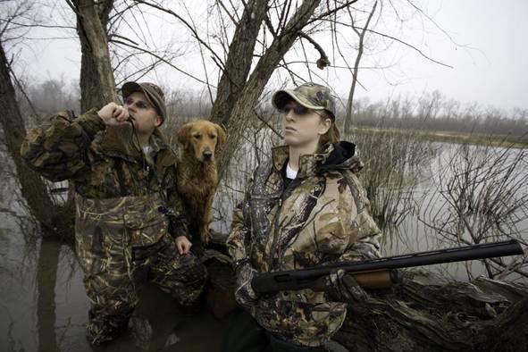 Man and a woman waterfowl hunting.