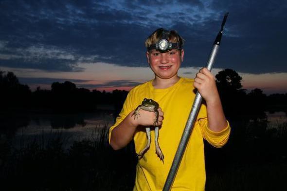 smiling boy with caught bullfrog