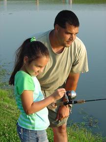 Girl pond fishing with adult man