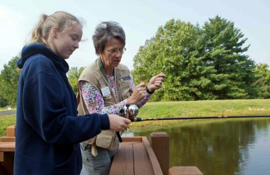 woman teaches girl to fish