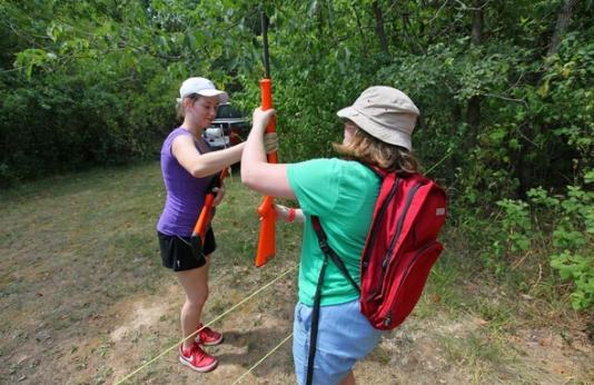 Two women take hunter education skills session outdoors.