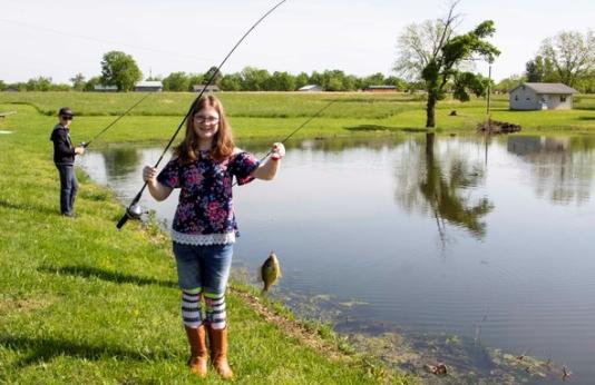Young girl shows off fish caught on pole-and-line