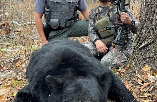 hunter and agent with harvested bear