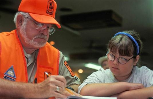 Hunter education instructor goes over test with young girl