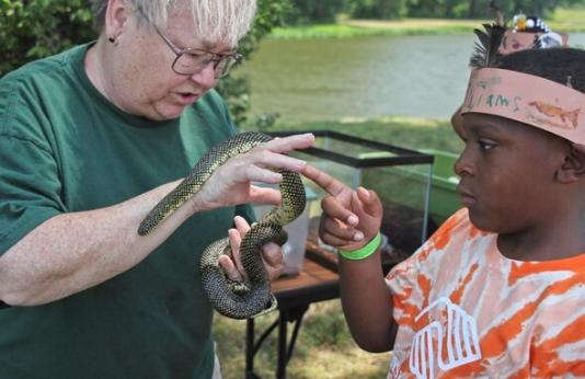 MDC staff show a young boy a snake
