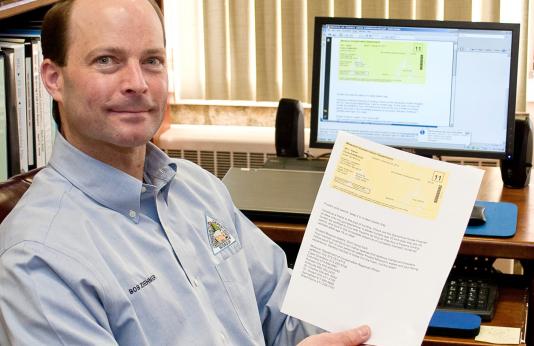 Bob Ziehmer hold an e-permit printed in his office. 