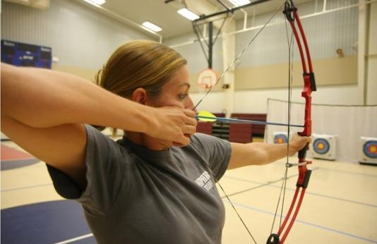 Teacher shooting a bow.