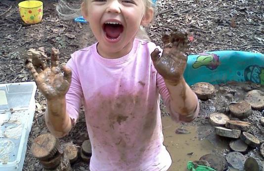 Muddy girl playing in the mud.