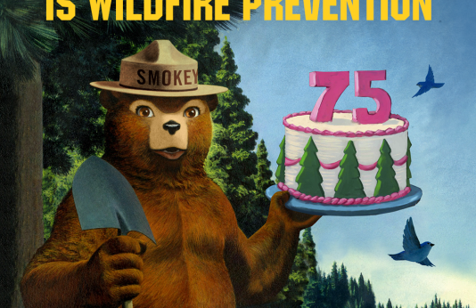 Smokey Bear holding his 75th Birthday cake.