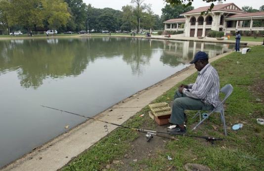 Man in chair fishing next to lake at St. Louis City’s O’Fallon Park