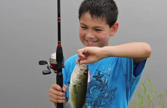 A young angler poses with a fish he caught at a Missouri pond.