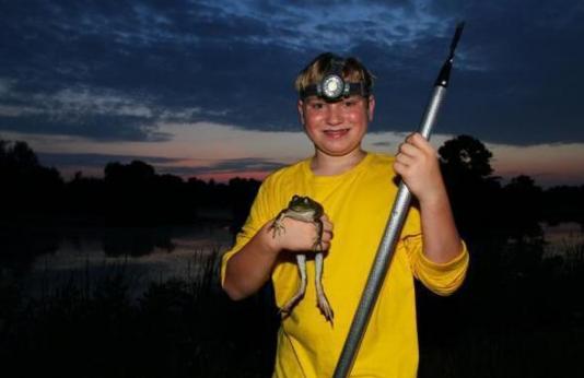 smiling boy with caught bullfrog