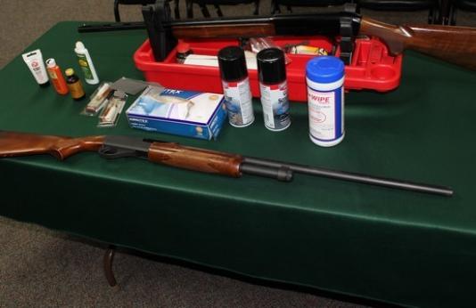 items on a table used for firearms care and a rifle and shotgun