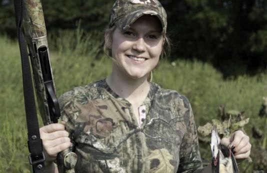 A female hunter shows off a bird she harvested.