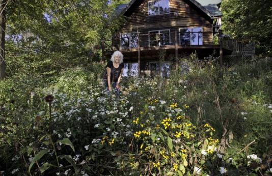 A landowner poses behind her wildflower garden.