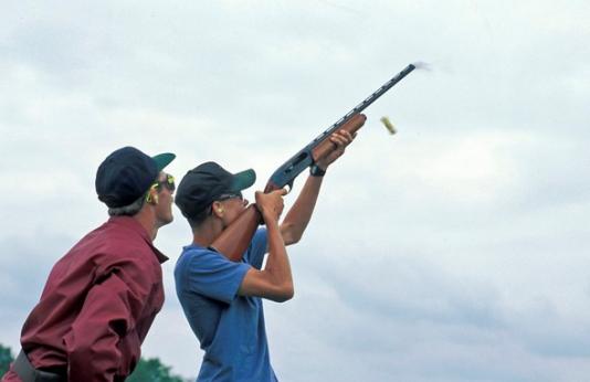 man teaches young man shotgun shooting